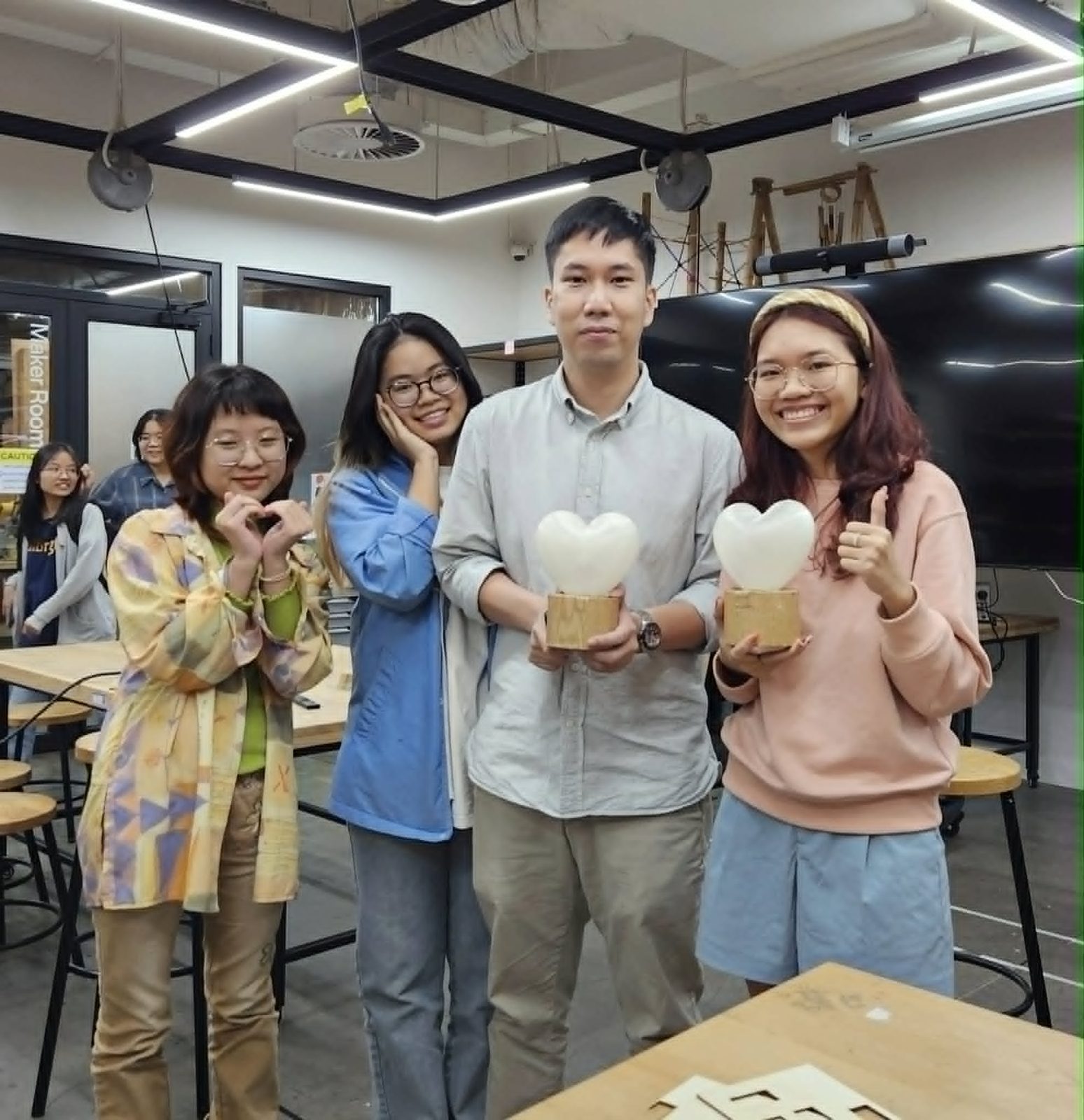 Anne and teammates holding their 3D-printed heart-shaped product