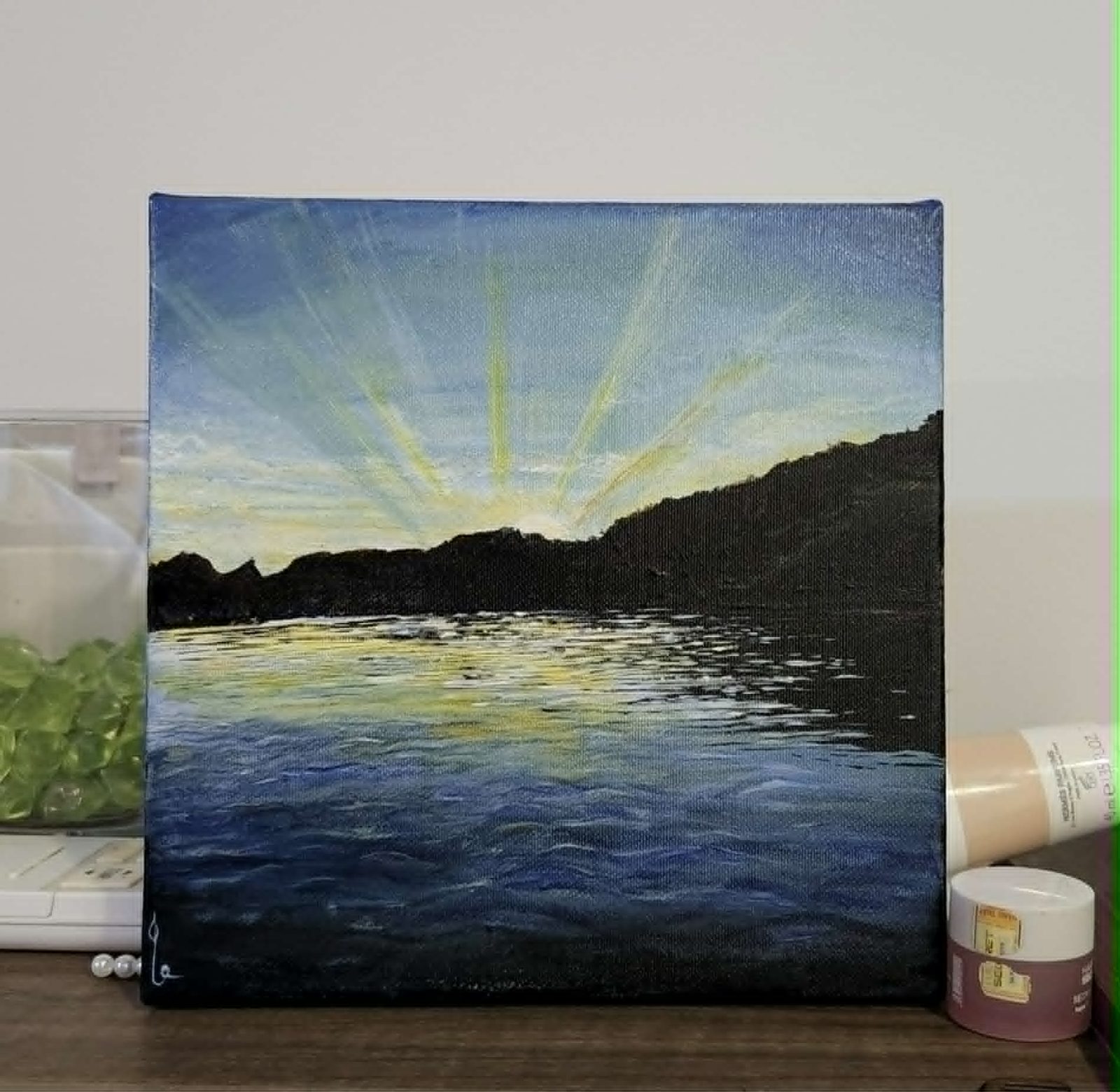 Acrylic painting of sun rays over a mountain lake